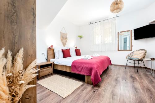 a bedroom with a bed with a red blanket at bed&breakfast Bohemian in Rovinj