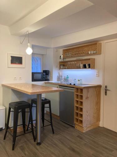 - une cuisine avec une table et quelques tabourets dans l'établissement La Cabine, à Granville