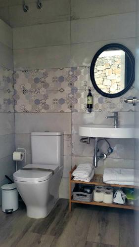 a bathroom with a toilet and a sink and a window at Casas Rurales Maribel - Complejo Moradas del Cerro 1 - Suites con Jacuzzi en Alcalá del Júcar in Casas del Cerro