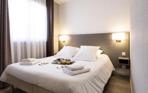 a hotel room with a bed with towels on it at SOWELL RESIDENCES Pra Loup in Pra-Loup