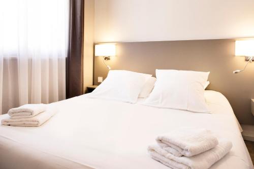 a bedroom with a white bed with towels on it at SOWELL RESIDENCES Pra Loup in Pra-Loup