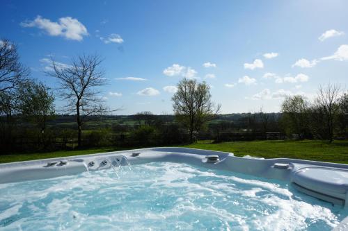 a jacuzzi tub with water in a yard at Hillcrest Barn. in Tenby