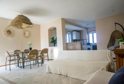 Una sala de estar con un sofá, una mesa y sillas. en Atico BLUE Beach, en El Puerto de Santa María