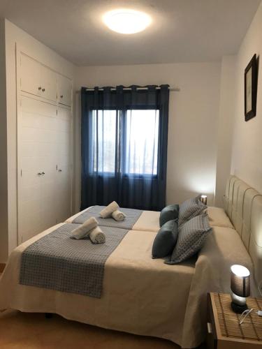 a bedroom with a large bed with pillows and a window at Playa Honda vistas al mar, 1a Línea playa, PARKING, WIFI in Playa Honda