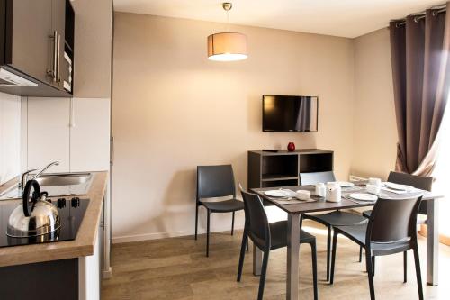 a kitchen and dining room with a table and chairs at SOWELL RESIDENCES Pra Loup in Pra-Loup