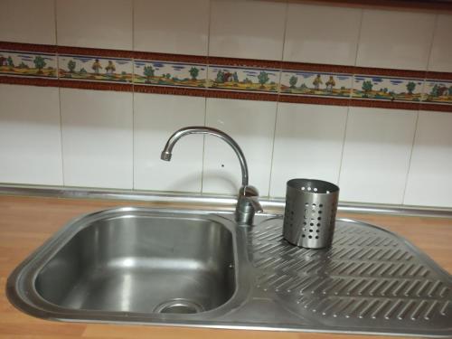 un fregadero de acero inoxidable con una taza encima en PME Rooms, en Madrid