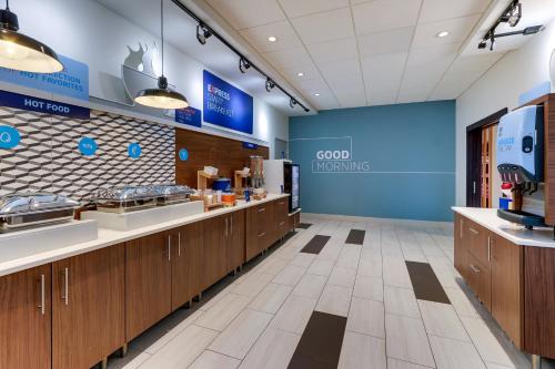 a cafeteria with wooden counters and a blue wall at Holiday Inn Express & Suites - Middletown - Goshen by IHG in Middletown