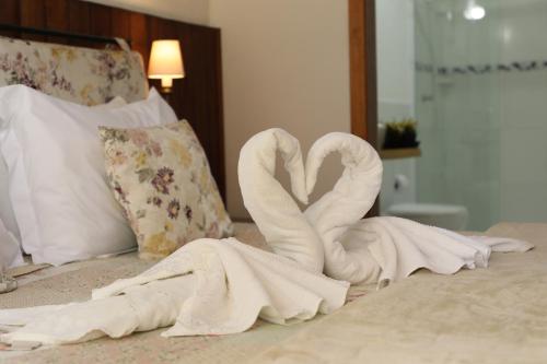 dos cisnes de toalla sentados en la parte superior de una cama en Casa do Papai, en Campos do Jordão
