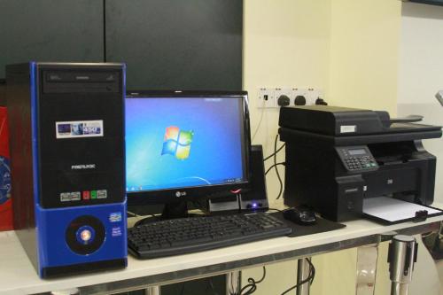 a desk with a desktop computer and a computer printer at One Avenue Hotel in Petaling Jaya