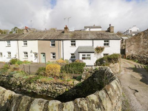 a stone wall in front of a house at 14 Low Row in Holker