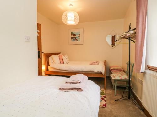 a bedroom with two beds and a mirror at 14 Low Row in Holker
