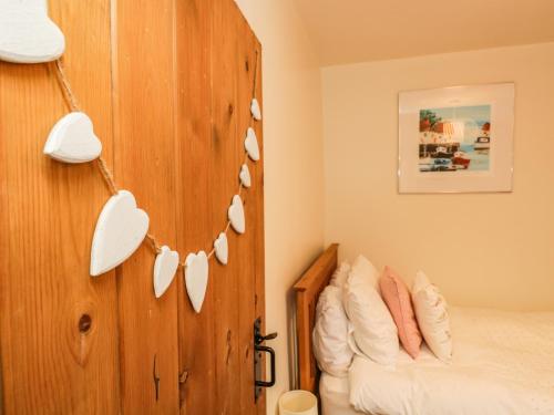 a bedroom with a wooden wall with white hearts on it at 14 Low Row in Holker