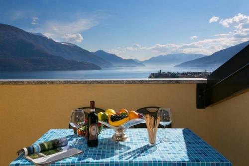 a table with a bowl of fruit and wine glasses at Residenza Christian in Gravedona