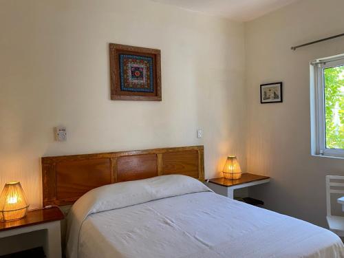 a bedroom with a bed and two tables with lamps at Hotel La Piazzetta in Mérida