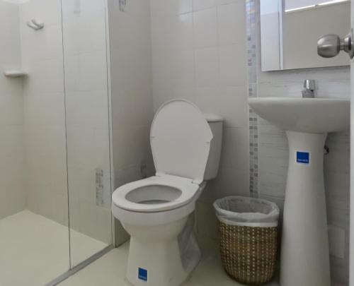 a bathroom with a toilet and a sink at Hotel Iraka Zenu in Sincelejo