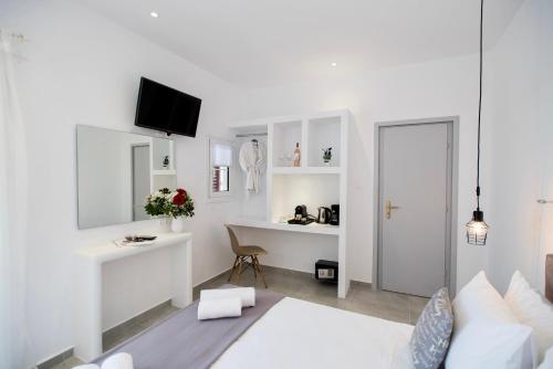 a white room with a bed and a desk at Myconian Little Venice Elite Suites with Sea View in Mýkonos City