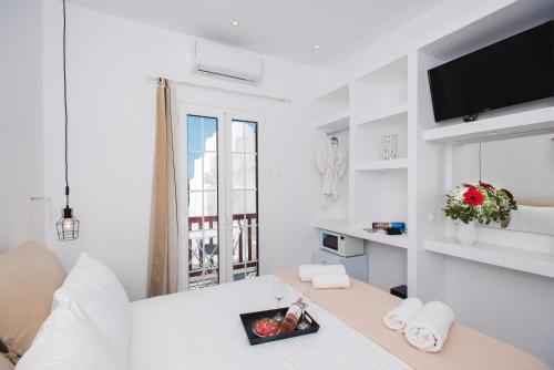 a white room with a bed and a window at Myconian Little Venice Elite Suites with Sea View in Mýkonos City