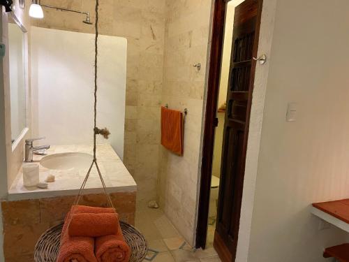 a bathroom with a sink and a shower with towels at Hotel La Piazzetta in Mérida