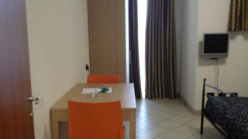 a room with a table and two orange chairs at Hotel Residence Le Terrazze in Portovenere