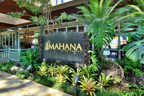 a sign in front of a building with plants at Mahana at Kaanapali in Kaanapali