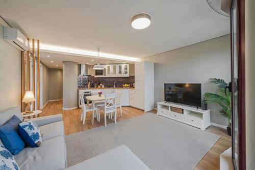 a living room with a white couch and a kitchen at The Boats Apartment by An Island Apart in Funchal