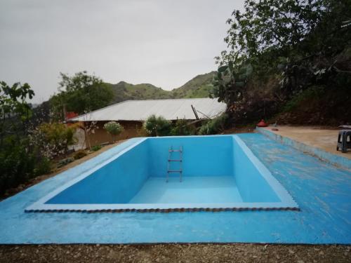 ein blauer Pool mit einem Stuhl in der Mitte in der Unterkunft Nefzi Guest House in Nefzi