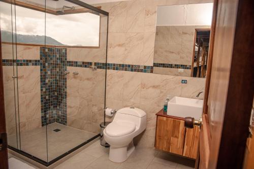 a bathroom with a shower and a toilet and a sink at Hotel Santa Laura in Jericó