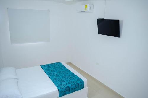 a room with a bed and a tv at Apartahotel y Hotel Sofichic Boutique in Barranquilla