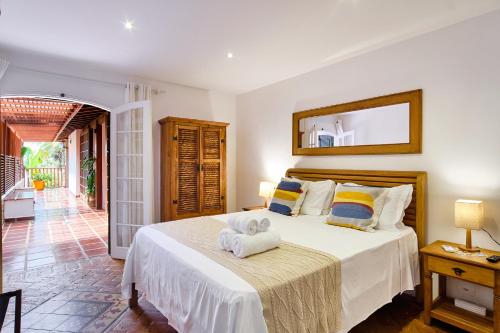 a bedroom with a bed with towels on it at Boutique Hotel Carpe Diem in Paraty