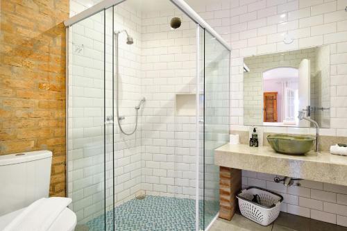a bathroom with a glass shower and a sink at Boutique Hotel Carpe Diem in Paraty