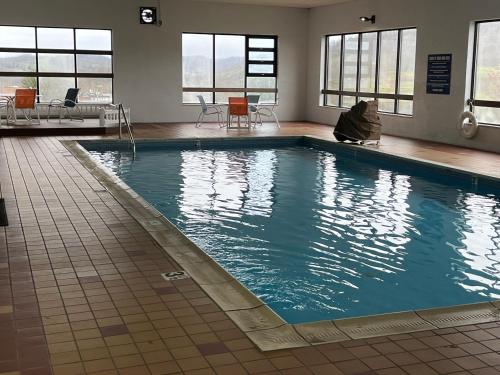 a large swimming pool in a building at Days Inn & Suites by Wyndham Sutton Flatwoods in Sutton