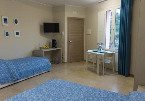 um quarto com uma cama, uma mesa e uma secretária em Oikos - Ragusa Ibla em Ragusa
