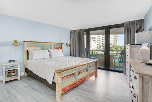 a bedroom with a bed and a balcony at Edgewater #308 in Destin