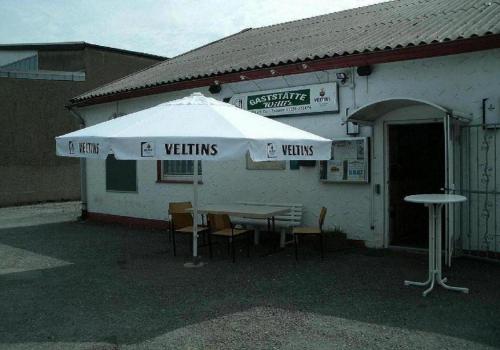 un paraguas blanco sentado fuera de un edificio en Gaestehaus Willis -Monteurzimmervermietung- en Vienenburg
