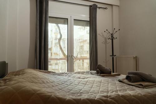 a bedroom with a bed and a large window at Theo Apartments in Thessaloniki