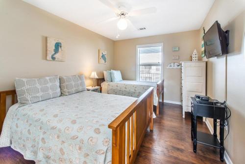 a bedroom with a bed and a dresser and a television at Beachside Villas 332 in Santa Rosa Beach