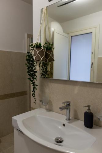 a bathroom with a white sink and a mirror at Oikos - Ragusa Ibla in Ragusa