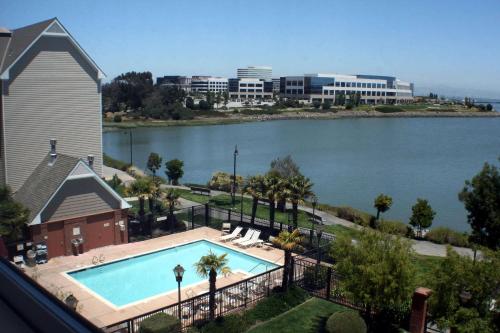 a swimming pool next to a large body of water at Sonesta ES Suites San Francisco Airport Oyster Point Waterfront in South San Francisco