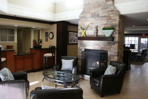 a living room with chairs and a fireplace at Sonesta ES Suites San Francisco Airport San Bruno in San Bruno