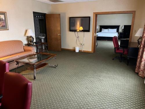 a hotel room with a couch and a bed at Days Inn & Suites by Wyndham Sutton Flatwoods in Sutton