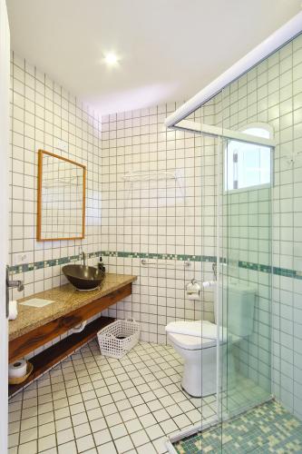 a bathroom with a toilet and a sink and a mirror at Boutique Hotel Carpe Diem in Paraty