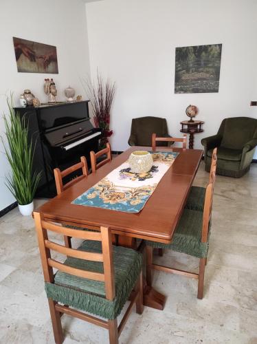a dining room table with chairs and a piano at Da Marilù in Mazara del Vallo