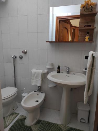a white bathroom with a sink and a toilet at Da Marilù in Mazara del Vallo
