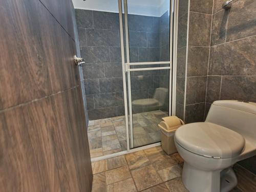 a bathroom with a toilet and a shower at Hotel Monte Bello in Doradal