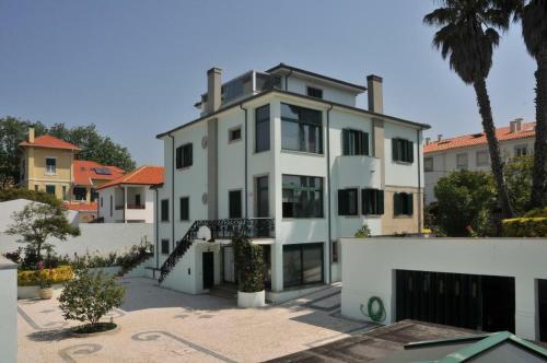 a white building with a palm tree in front of it at Francelos Village in Vila Nova de Gaia