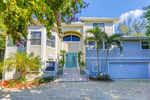 a house with a blue door and palm trees at Coconut Palm House in Captiva