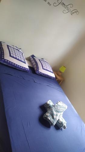 uma cama com duas almofadas e um bicho de peluche em La petite campagne em Le Moule