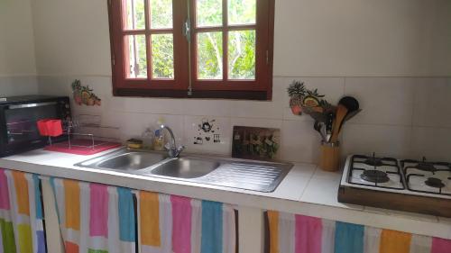 a kitchen counter with a sink and a stove at La petite campagne in Le Moule