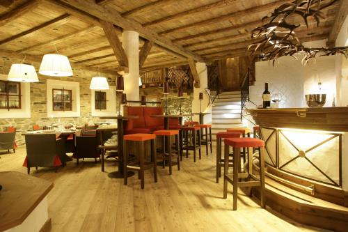 a restaurant with chairs and tables and a bar at Hotel Bertelli in Madonna di Campiglio