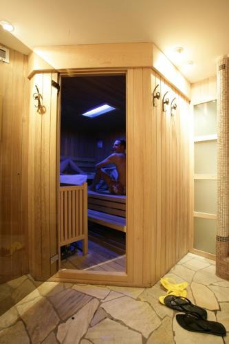a man is in a bed in a room at Hotel Bertelli in Madonna di Campiglio